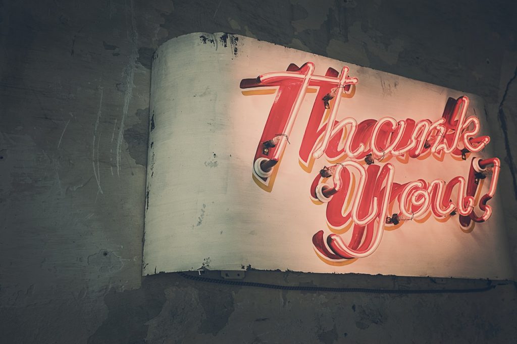 Say thank you to everyone, on a regular basis. Image shows the words thank you in neon