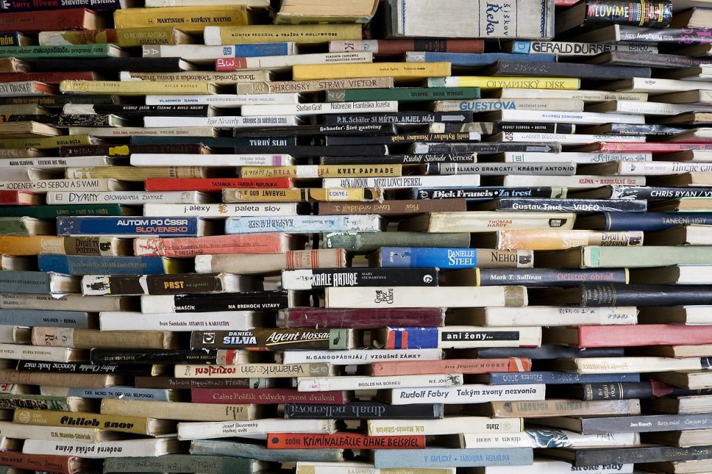 Do you have tsundoku habit?Image shows lots of books arranged in a wall with gaps in between