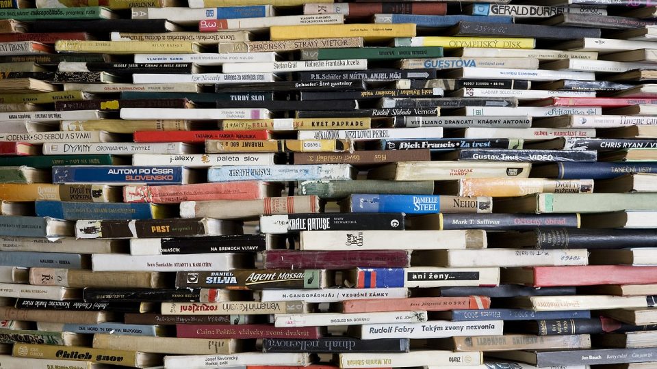 Do you have tsundoku habit?Image shows lots of books arranged in a wall with gaps in between