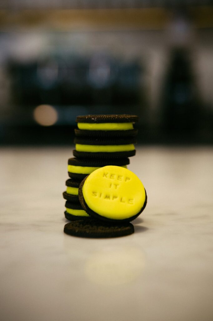 Keep things simple. Image shows yellow and black cookies with the words keep it simple pressed in