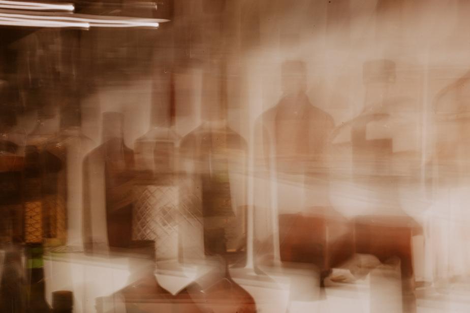 Image is a blurry abstract of glass bottles