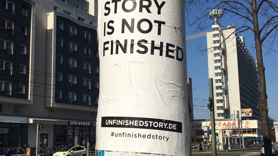 A posted on a lamp post which says "Your story is not finished"